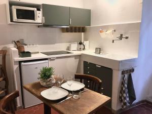 a small kitchen with a wooden table with glasses on it at Sainte Anne in Apt