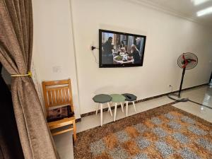 a living room with two stools and a tv on the wall at شاليه جديد في مارينا دلتا لاجونز in Balṭîm