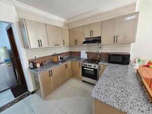a kitchen with granite counter tops and stainless steel appliances at شاليه جديد في مارينا دلتا لاجونز in Balṭîm