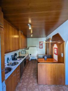 a kitchen with wooden cabinets and a white refrigerator at Spacious Room in Tyrolean Flat in Innsbruck +4 photos