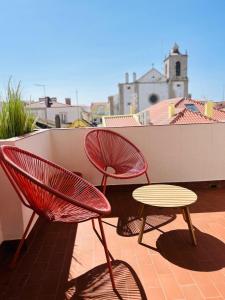 two red chairs and a table on a balcony at Ponte Velha in Peniche