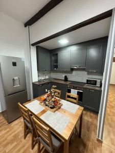 eine Küche mit einem Holztisch mit Stühlen und einem Tisch in der Unterkunft Casa Nito in Sardina