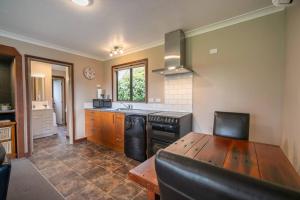 a kitchen with a table and a stove top oven at Te Anau Cottage in Te Anau