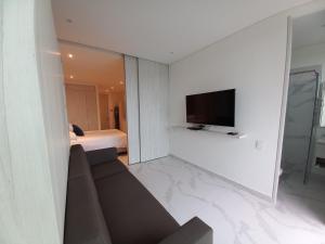 a living room with a couch and a flat screen tv at Playa y Relax comodidad junto al mar! in Santa Marta