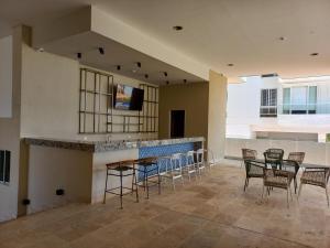 a lobby with tables and chairs and a bar at Playa y Relax comodidad junto al mar! in Santa Marta