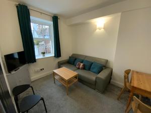 ein Wohnzimmer mit Sofa und Tisch in der Unterkunft Centrally located, beautifully presented apartment in Torquay
