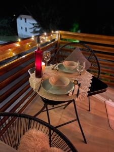una mesa con platos y copas de vino en el balcón en Casa mia, en Zlatibor