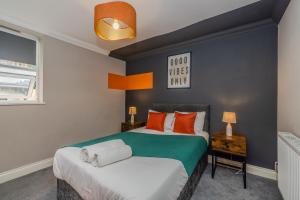 une chambre avec un grand lit avec des oreillers orange dans l'établissement Super Central 1 Bedroom Flat With Balcony Next To Brighton Beach, à Brighton et Hove 14 autres photos