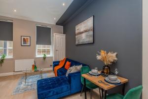 un salon avec un canapé bleu et une table dans l'établissement Super Central 1 Bedroom Flat With Balcony Next To Brighton Beach, à Brighton et Hove