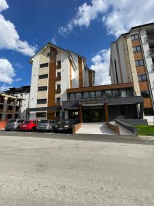 Un edificio con coches aparcados en un estacionamiento. en Casa mia, en Zlatibor