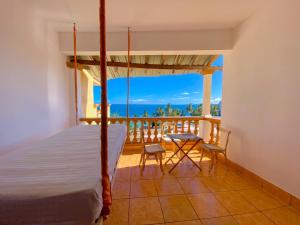 a bedroom with a bed and a balcony with a view at Shanzu Reef Beachfront Apartments in Mombasa
