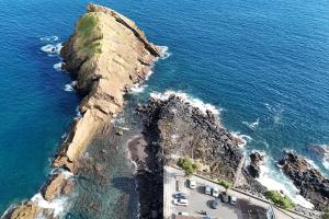 an aerial view of a rocky cliff next to the ocean at R&M Place in São Roque