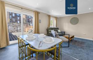 a living room with a table and chairs and a couch at L1 - INVOICE and REDUCED PRICE only via SUNRISE SHORT LETS DUNDEE, Large 4 Bedroom House with 6 Beds and 3 bathrooms, TVs in each room, Free Parking, Fully Equipped, Local Amenities, Easy Ring Road Access, Special Rates in Dundee