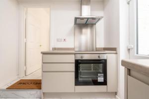 リバプールにあるLiverpool Luxe Retreat 3 Bedroom House Next to Everton Stadiumのコンロ付きのキッチン 戸口の横にある上のオーブン