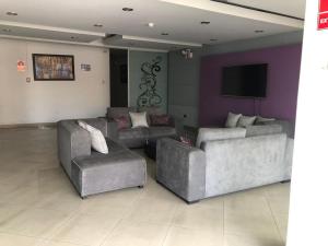 a living room with two couches and a flat screen tv at Gran Hotel Victoria in Tacna