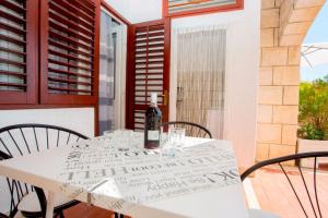 eine Flasche Wein auf einem Tisch mit Stühlen in der Unterkunft Apartments and Rooms Hope in Brela