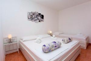zwei Betten in einem Zimmer mit weißen Wänden in der Unterkunft Apartments and Rooms Hope in Brela