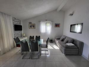 a living room with a couch and a table at Apartments Villa Smokvina in Bogomolje
