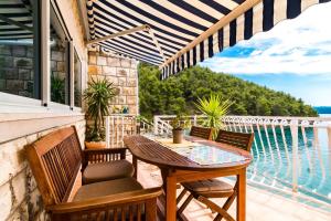 a patio with a table and chairs on a balcony at Apartments Villa Smokvina in Bogomolje