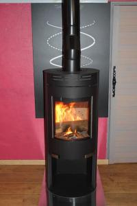 Chalet de la Lette في فينترون: موقد أسود مع النار في الغرفة +46 صورة