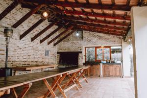 a kitchen with wooden tables and a brick wall at El Colonial Departamentos in Cafayate