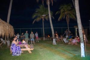 a group of people sitting at tables on the beach at night at Bella Vista Hotel Boutique in San Miguel