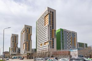 a group of tall buildings in a parking lot at Apartments 7 Я-14 in Astana