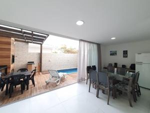 a kitchen and dining room with a table and chairs at Linda casa 3 Praia Ponta do Papagaio 190mt mar in Palhoça