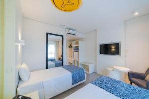 a hotel room with two beds and a tv at ibis Styles Maracanau in Maracanaú +109 photos