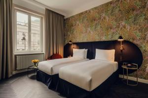 a hotel room with two beds and a window at Flaner Hotel, WorldHotels Crafted in Warsaw +86 photos