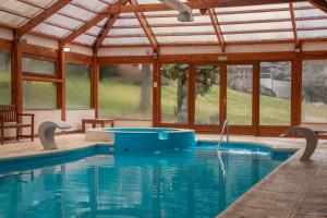 a swimming pool in a pavilion with a swimming pool at Bosque Dormido Cabañas & Spa in San Carlos de Bariloche