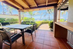 a dining room with a table and chairs on a patio at Villa 8 frente al mar in Zihuatanejo