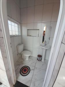 a bathroom with a toilet and a sink at Sobrado da Nice in Presidente Epitácio +7 photos