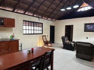 a living room with a wooden table and chairs at Cabañas y hospedaje Sol y Luna Motul in Motul de Felipe Carrillo Puerto