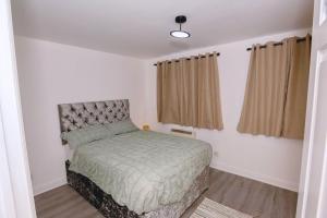 a small bedroom with a bed and curtains at Bright apartment in London