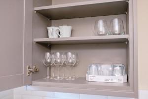a shelf with wine glasses and other items on it at Bright apartment in London