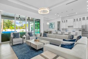 sala de estar con muebles blancos y cocina en Diamond Blue Beach Home, en Bonita Springs