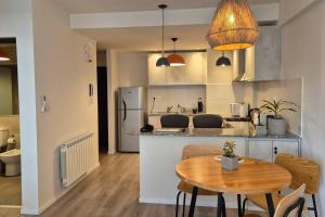Una cocina y un comedor con una mesa de madera. en Departamento Jujuy Norte, en San Salvador de Jujuy
