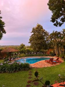 a pool in a yard with two chairs and flowers at La casita de CristAl in Puerto Rico