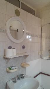 a bathroom with a sink and a mirror and a tub at Departamento Nini Villa Del Dique in Villa del Dique