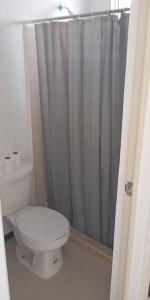a bathroom with a toilet and a shower curtain at Casa Adobe clima total Starlink zona Aeropuerto in Pesquería +24 photos