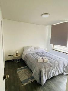 una camera da letto bianca con un letto e una finestra di Edificio Plaza del mar, Iquique a Iquique