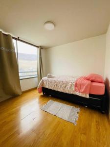 una camera da letto con un letto e una grande finestra di Edificio Plaza del mar, Iquique a Iquique