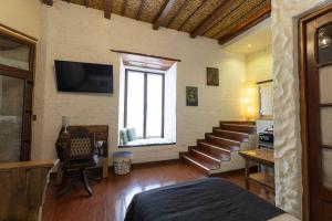 Habitación con cama, ventana y escaleras en On Hotel Boutique, en Sucre