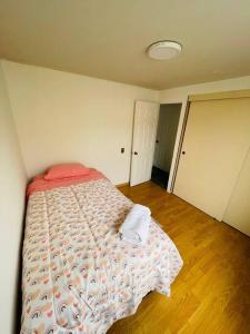 una camera da letto con un letto con un piumone rosso e bianco di Edificio Plaza del mar, Iquique a Iquique