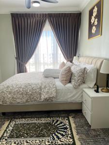 a bedroom with a bed with purple curtains and a window at Amliza homestay in Cyberjaya