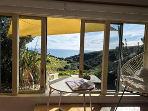 a view of the ocean from the porch of a house at Raglan Lovebus in Raglan