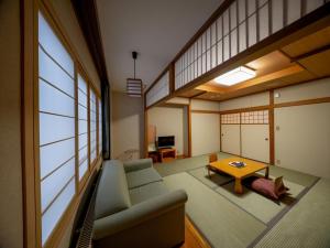 a living room with a couch and a table at REBUN Hotel SARYO in Kafuka
