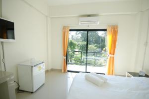a bedroom with a bed and a large window at Sunee Boutique Hotel in Uttaradit