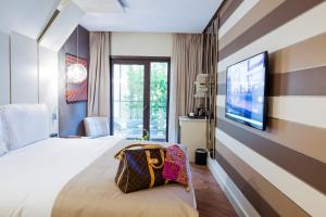 um quarto de hotel com uma cama e uma televisão de ecrã plano em Maroon Hotel Pera em Istambul